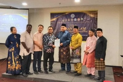 Mohamad Zapawi (empat dari kanan) menyerahkan memorandum kepada Radin Muhd. Imaduddin (lima dari kanan) dalam satu program di Ipoh baru-baru ini.