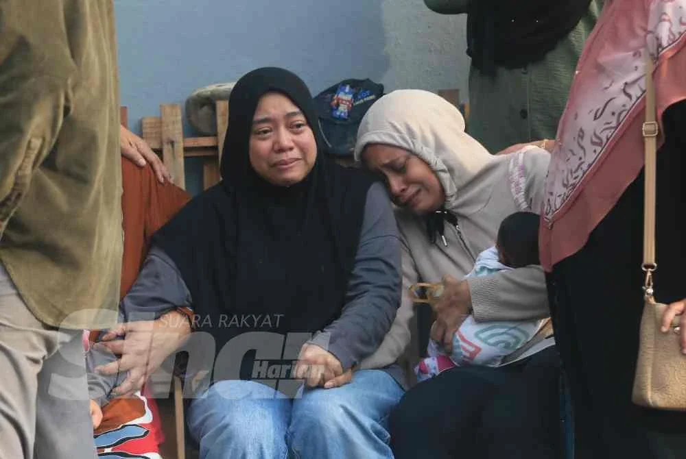Nur Izzah (duduk, kiri) tidak mampu menahan sebak ketika ditemui di Jabatan Forensik Hospital Sultan Zainal Abidin (HoSZA) di Kuala Nerus pada Rabu.
