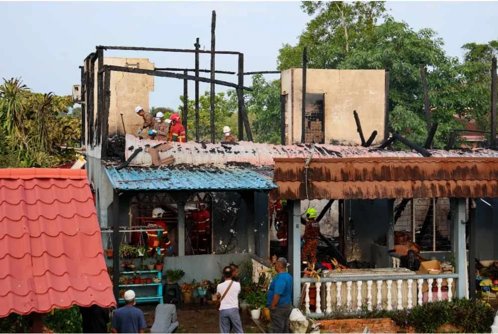 Anggota JBPM melakukan operasi mencari dan menyelamat dua mangsa yang maut dalam kebakaran di Kampung Tok Jembal, awal pagi Rabu. Foto Bernama