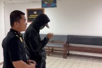 Tertuduh (kanan) ketika dihadapkan di Mahkamah di Kuala Terengganu pada Rabu.