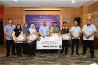 Syamsul Hazeman (lima dari kiri) selepas menyampaikan komputer riba kepada penerima sempena Program Seminar Kecemerlangan SPM 2026 di sebuah hotel di sini pada Rabu.