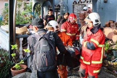 Anggota bomba mengeluarkan mayat mangsa yang terkorban dalam kebakaran melibatkan sebuah rumah di Kampung Tok Jembal, Kuala Nerus awal pagi Rabu. 