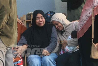 Nur Izzah (duduk, kiri) tidak mampu menahan sebak ketika ditemui di Jabatan Forensik Hospital Sultan Zainal Abidin (HoSZA) di Kuala Nerus pada Rabu.
