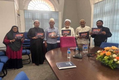 Kakitangan Masjid Wakaf Tembesu dan Rumah Ngaji Terengganu memegang plakad sempena Malaysia #QuranHour yang akan diadakan pada 30 Ogos ini.