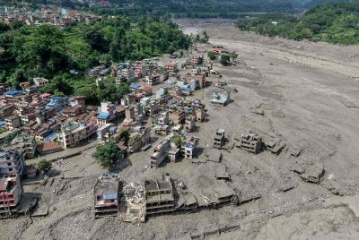 Rumah-rumah kelihatan sebahagiannya ditenggelami air berlumpur di sepanjang kawasan tebing sungai selepas banjir kilat melanda Trishuli Bazar, daerah Nuwakot, Nepal pada 26 Ogos 2026. Foto AFP