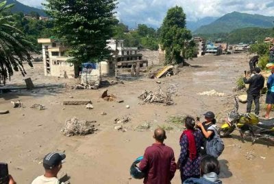 Penduduk melihat rumah-rumah yang sebahagiannya ditenggelami air berlumpur selepas banjir kilat melanda Trishuli Bazar, daerah Nuwakot, Nepal pada 26 Ogos 2026. Foto AFP