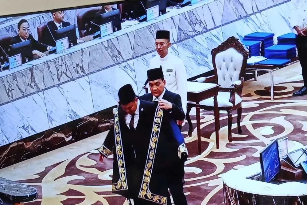 Onn Hafiz memakaikan jubah Speaker Johor ketika Persidangan Pertama Dewan Negeri Johor yang ke-16 di Dewan Sidang Negeri Bangunan Sultan Ismail pada Khamis.