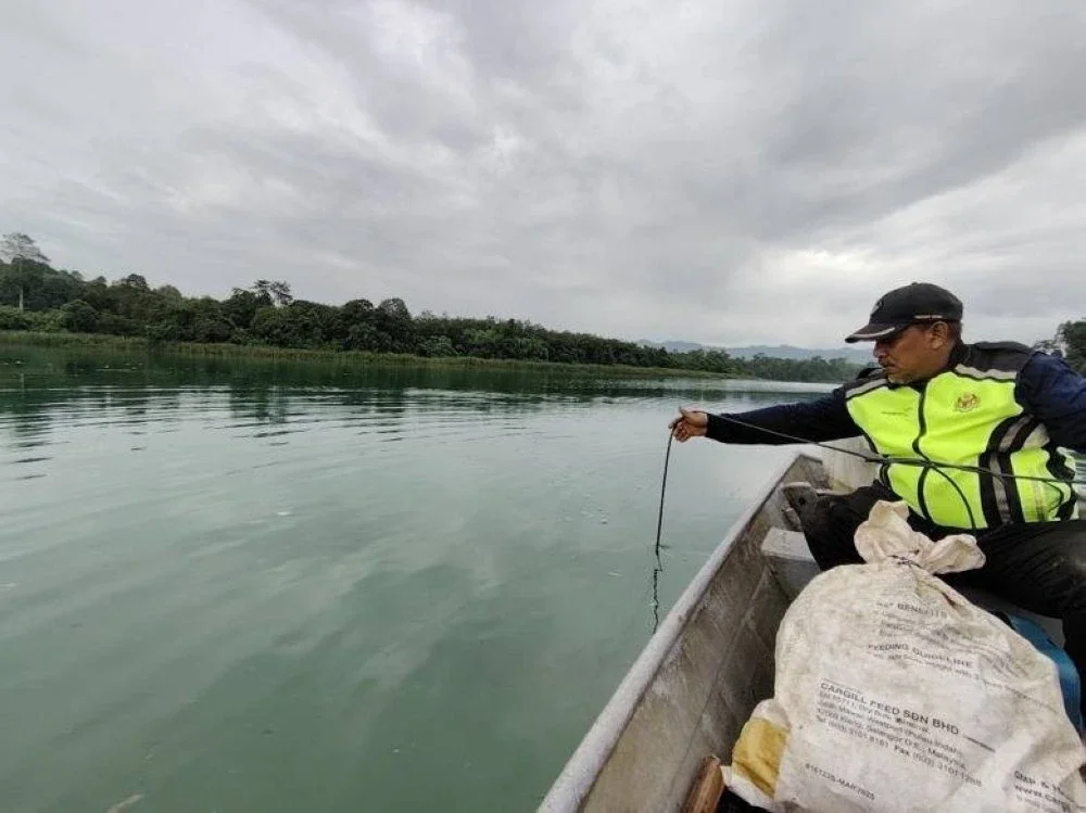 Kakitangan Jabatan Alam Sekitar Negeri Perak mengambil sampel di Sungai Perak bagi mengenal pasti kualiti air susulan fenomena air sungai tersebut berubah warna menjadi biru.