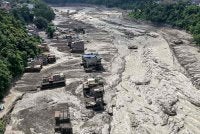 Rumah-rumah kelihatan sebahagiannya ditenggelami air berlumpur di sepanjang kawasan tebing sungai selepas banjir kilat melanda Trishuli Bazar, daerah Nuwakot, Nepal pada 26 Ogos 2026. Foto AFP