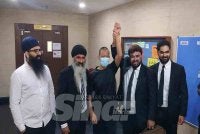 Keshvinder mengangkat tangan Aszizi (tengah) selepas dilepas dan dibebaskan oleh Mahkamah Sesyen Ipoh pada Khamis.