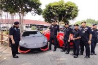 Jasyindar (dua dari kiri) menunjukkan Lamborghini yang disita kerana tiada cukai jalan.