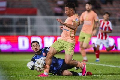 Pemain Kuching City, Muhammad Ramadhan Saifullah Usman (kanan) cuba merampas bola dari penjaga gol KL City, Quincy Julian Boltron Kammerad (kiri) pada perlawanan Liga Super di Stadium Bolasepak Kuala Lumpur pada Rabu. Foto Bernama