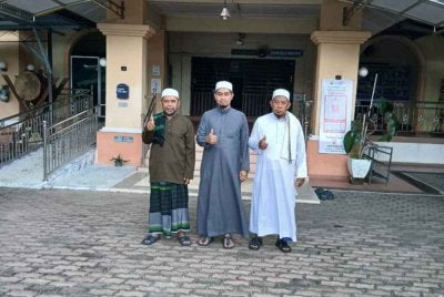 Wan Muhammad (tengah) bergambar di hadapan Masjid Al-Munir, Mukim Badang, Kota Bharu bersama Imam Muda, Mohd Fadhil Mat Yusof (kanan) dan Bendahari, Saidi Latif (kiri).