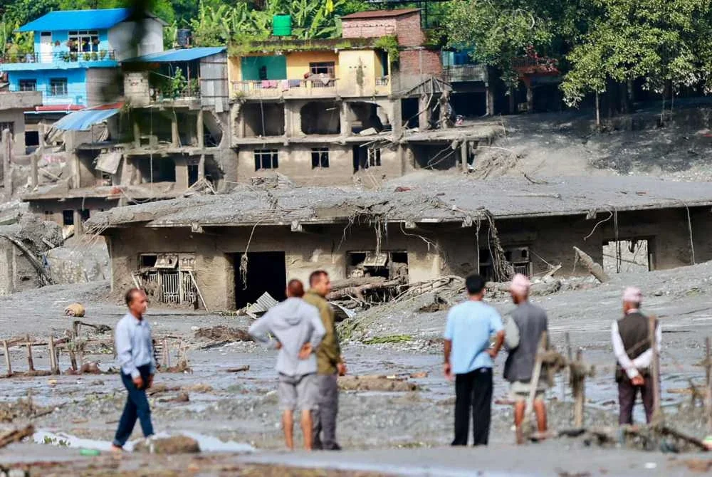 Penduduk tempatan memeriksa rumah yang ditenggelami lumpur selepas banjir melanda Devighat, Perbandaran Bidur, di daerah Nuwakot, Nepal. Foto AFP