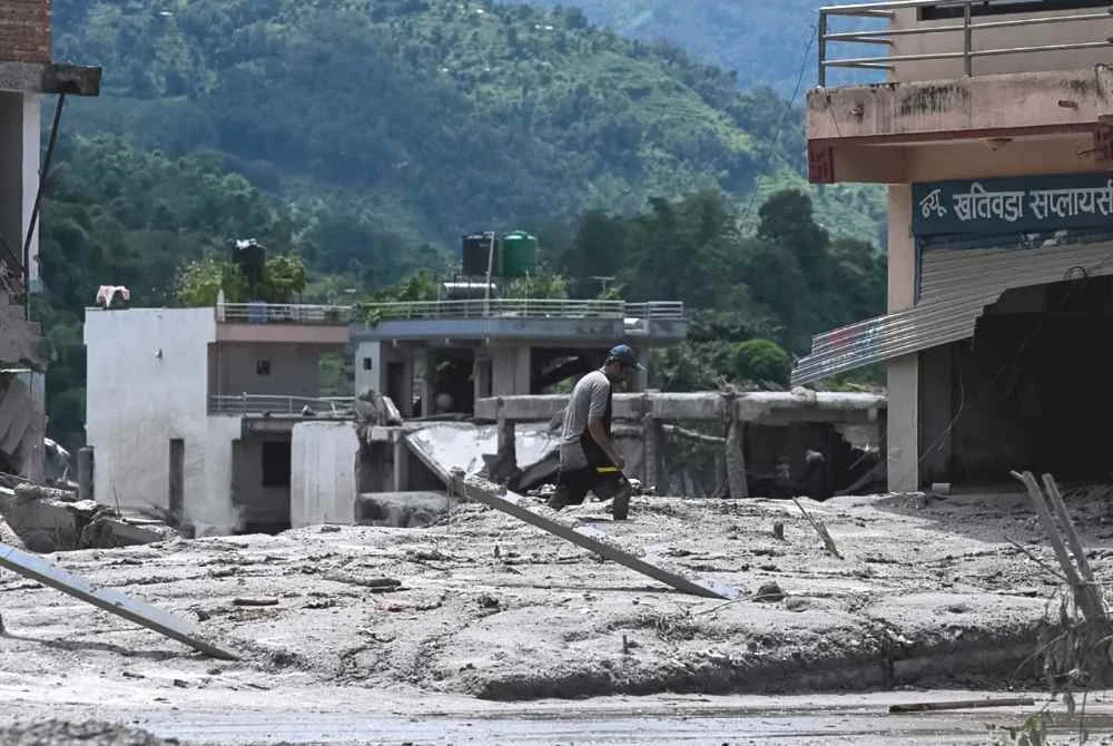 Seorang lelaki menyelamatkan barangan miliknya dari rumah yang ditenggelami lumpur selepas banjir kilat melanda kawasan Devighat di daerah Nuwakot, Nepal, pada 27 Ogos 2026. Foto AFP