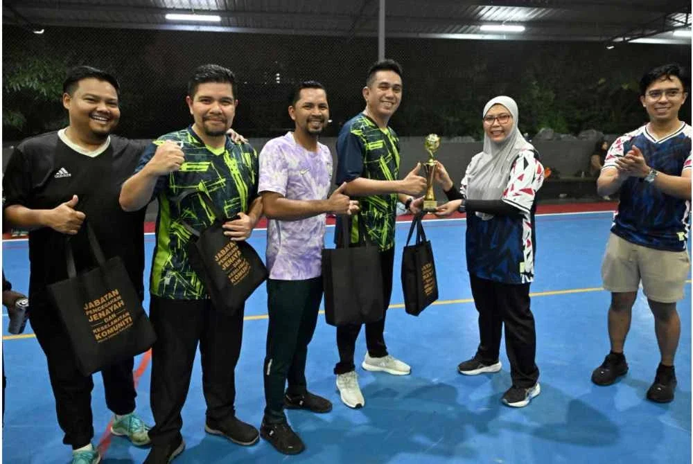 Safeek Affendy (tengah) menerima cenderamata yang diserah Julina sempena perlawanan persahabatan futsal dan bola jaring di Setapak, Kuala Lumpur pada Khamis