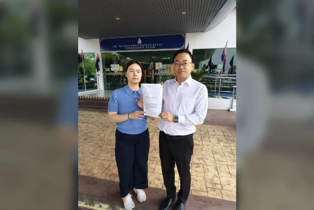 Bor Yang (kanan) menunjukkan laporan polis yang dibuat di IPD Kulai.