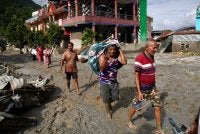 Penduduk tempatan berjalan melintasi rumah yang ditenggelami lumpur akibat banjir berhampiran Devighat, Perbandaran Bidur, di daerah Nuwakot, Nepal. Foto AFP