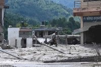 Seorang lelaki menyelamatkan barangan miliknya dari rumah yang ditenggelami lumpur selepas banjir kilat melanda kawasan Devighat di daerah Nuwakot, Nepal, pada 27 Ogos 2026. Foto AFP