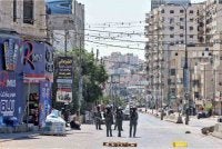 Anggota tentera Israel mengawal seorang lelaki Palestin yang ditahan ketika serbuan di Pusat Latihan Vokasional UNRWA, yang terletak antara kawasan kejiranan Kafr Aqab dan kem pelarian Qalandia, di selatan bandar Ramallah, Tebing Barat. Foto AFP