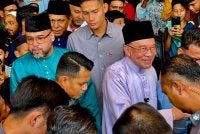 Anwar bersalaman dengan penduduk di pekarangan Masjid Sembilang di sini pada Jumaat.