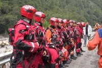 Anggota pasukan bomba dan penyelamat berkumpul sebelum menjalankan operasi menyelamat di satu bahagian jalan menuju Pelabuhan Gyirong yang rosak akibat tanah runtuh dua hari lalu, di Daerah Gyirong, wilayah Tibet, China. - AFP