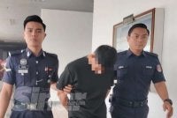 Tertuduh (tengah) mengaku tidak bersalah terhadap pertuduhan dibacakan ke atasnya pada Jumaat. 