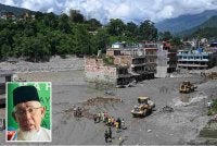 Sukarelawan menggunakan jentolak untuk membersihkan lumpur dan serpihan di sepanjang jalan susulan banjir kilat di Trishuli, daerah Nuwakot, Nepal. Foto AFP (Gambar kecil: Mohd Azmi)