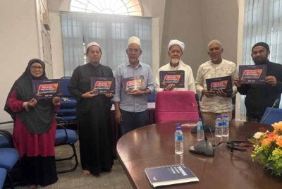 Kakitangan Masjid Wakaf Tembesu dan Rumah Ngaji Terengganu memegang plakad sempena Malaysia #QuranHour pada 30 Ogos ini.