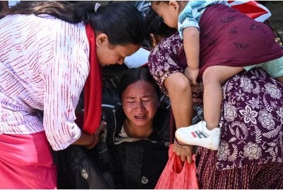 Seorang wanita tidak dapat menahan sebak ketika menunggu ketibaan saudara-maranya di sebuah kem tentera selepas diselamatkan dari kawasan yang terjejas akibat banjir kilat, di bandar Battar Bazar, daerah Nuwakot, Nepal. Foto AFP