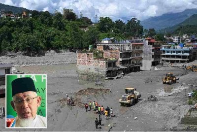 Sukarelawan menggunakan jentolak untuk membersihkan lumpur dan serpihan di sepanjang jalan susulan banjir kilat di Trishuli, daerah Nuwakot, Nepal. Foto AFP (Gambar kecil: Mohd Azmi)