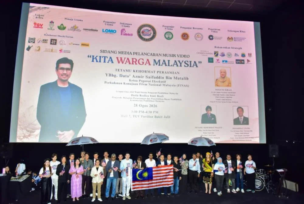 Tetamu kenamaan mengibar Jalur Gemilang dan memakai payung simbolik keharmonian masyarakat berbilang kaum yang hidup aman di bawah nama Malaysia.