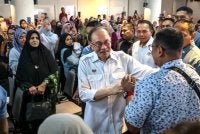 Anwar bersalaman dengan orang ramai ketika hadir pada Majlis Peluncuran Skim Usahawan Bangkit (SUB) Madani Permatang Pauh di Yayasan Aman pada Sabtu. Foto Bernama