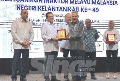 Mohd Shahar (dua dari kiri) menyampaikan plak penghargaan kepada kontraktor di Kelantan. 
