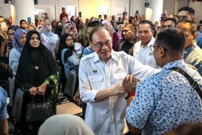 Anwar bersalaman dengan orang ramai ketika hadir pada Majlis Peluncuran Skim Usahawan Bangkit (SUB) Madani Permatang Pauh di Yayasan Aman pada Sabtu. Foto Bernama