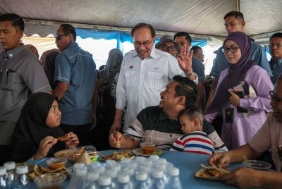 Anwar beramah mesra dengan orang ramai pada Majlis Peluncuran SUB Madani Permatang Pauh di Yayasan Aman pada Sabtu. FOTO: Bernama
