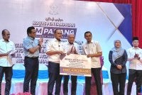 Wan Rosdy (tiga dari kiri) menyerahkan replika cek kepada Pengarah Pendidikan Jabatan Pendidikan Negeri Pahang (JPNP), Datuk Ahmad Zamri Md Isa.
