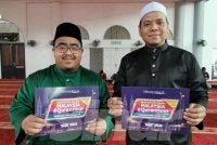 Amir Syakirin (kiri) bersama Pengerusi Rumah Ngaji Terengganu, Naib Ibrahim memegang plakad Malaysia #QuranHour di Masjid Wakaf Tembesu, Kuala Nerus pada Ahad.