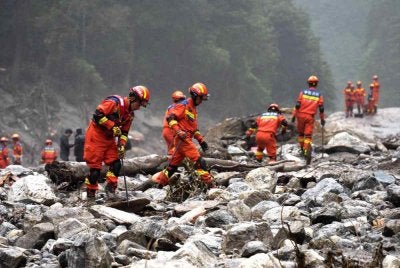 Anggota bomba dan penyelamat menjalankan operasi mencari dan menyelamat. Foto AFP