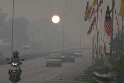 Matahari kelihatan suram diselubungi jerebu tebal menerusi satu pemandangan yang dirakamkan di sekitar Serian pada Ahad. - FOTO: Bernama 
