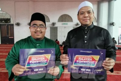 Amir Syakirin (kiri) bersama Pengerusi Rumah Ngaji Terengganu, Naib Ibrahim memegang plakad Malaysia #QuranHour di Masjid Wakaf Tembesu, Kuala Nerus pada Ahad.