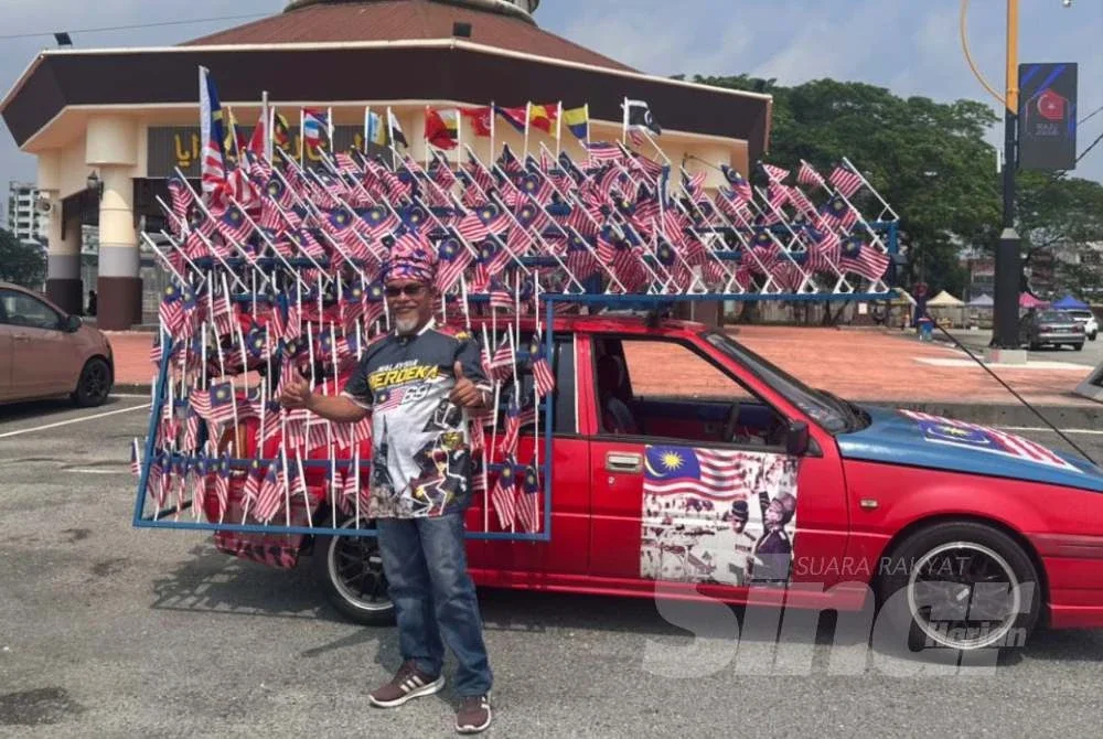 Arbaain bersama Proton Iswara miliknya yang dihiasi 369 bendera sempena Bulan Kebangsaan tahun ini.