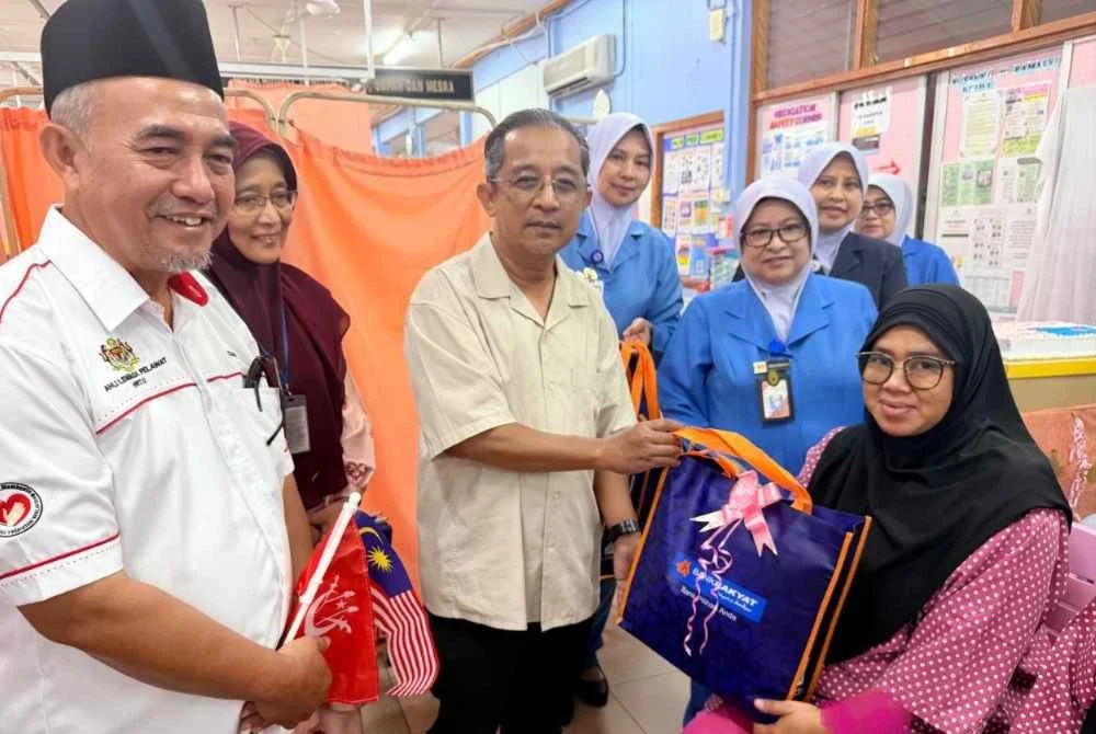 Nor Laila (kanan) menerima hadiah cenderamata daripada Dr Izamin pada Majlis Meraikan Program Sambutan Bayi Merdeka 2026 di HRPZ II, Kota Bharu pada Isnin.Foto:HRPZ II