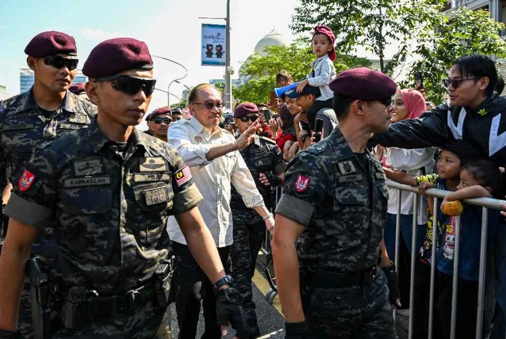 Anwar meluangkan masa beramah mesra dengan orang ramai yang hadir pada Sambutan Hari Kebangsaan 2026 di Dataran Putrajaya pada Isnin. Foto Bernama