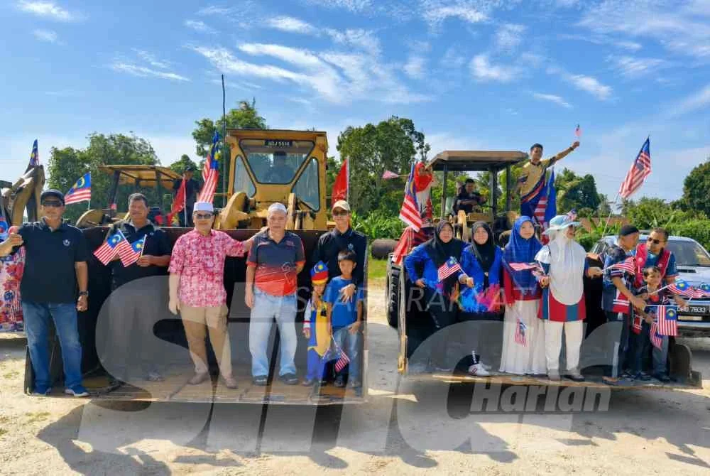 Zuraidin (tiga dari kiri) turut sama menaiki jentolak dan menyertai perarakan sempena sambutan Hari Kebangsaan ke-69 di DUN Chetok, Pasir Mas pada Isnin.
Foto:SINAR HARIAN/HAZELEN LIANA KAMARUDIN