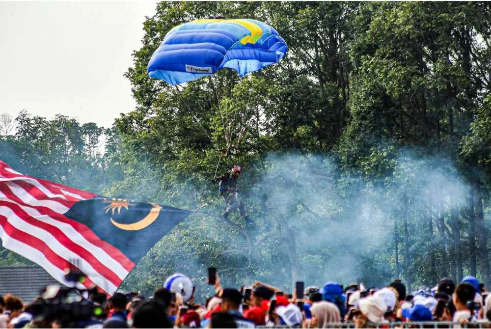 Aksi itu mencuri perhatian lebih 20,000 yang menyaksikan Jalur Gemilang gergasi dibawa turun dari langit. Foto Bernama
