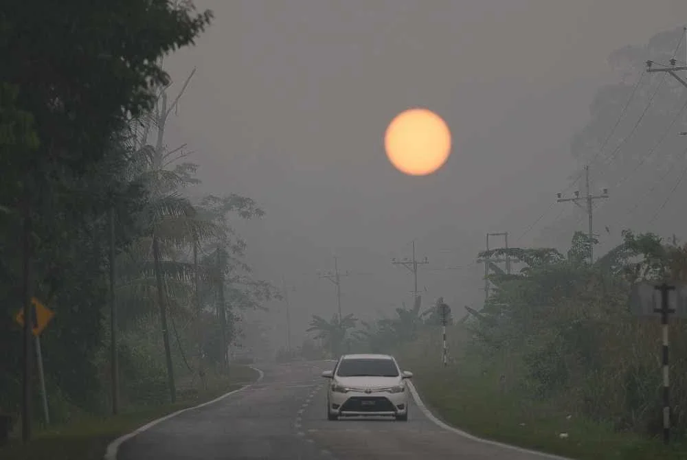 Matahari kelihatan suram diselubungi jerebu tebal menerusi satu pemandangan yang dirakamkan di Jalan Serian-Tebedu. - FOTO: Bernama