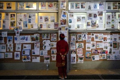 Seorang wanita melihat gambar-gambar orang hilang susulan kejadian banjir kilat di Hospital Pengajaran Universiti Tribhuvan di Kathmandu pada Ahad - Foto: AFP