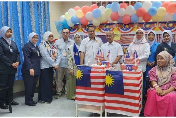 Salah seorang ibu dan 'bayi merdeka' merakam kenangan bersama barisan petugas kesihatan pada Hari Kemerdekaan ke-69 di HTAA - Foto: JKNP