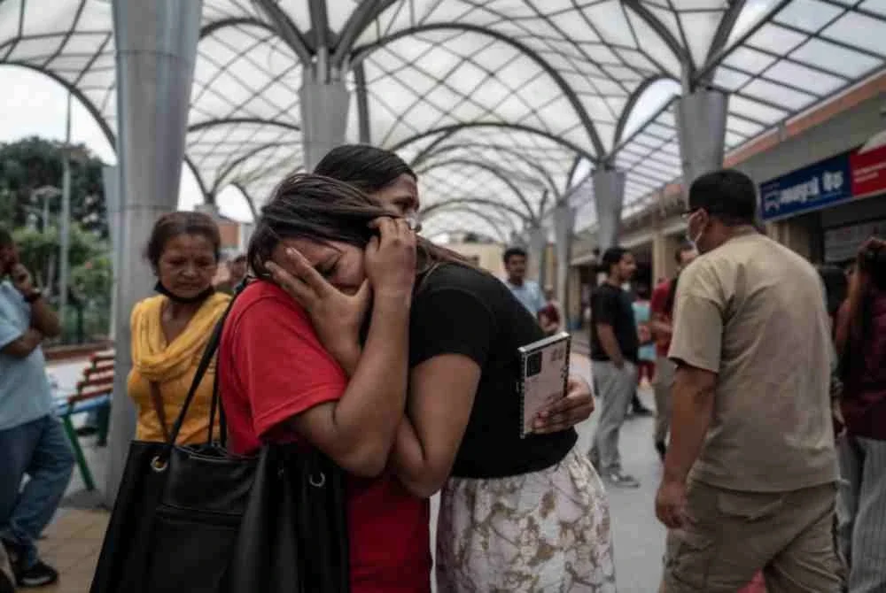 Monita Nepali (kanan) yang kehilangan suami dalam bencana itu ditenangkan oleh salah seorang ahli keluarganya. Foto: Agensi